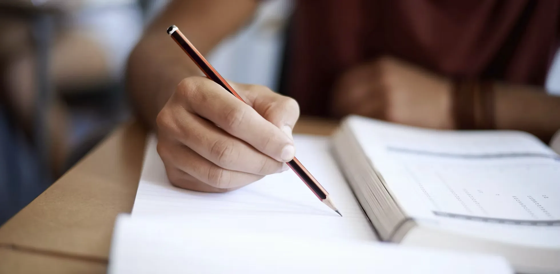A student working through coursework at a desk during a one-on-one session